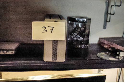 FBI search photo 72 — Item 37, final fabricated scene with hard drive back on the bookshelf